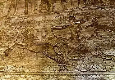Illustration de Sur un char tiré par deux coursiers au galop, Ramsès II décoche ses flèches